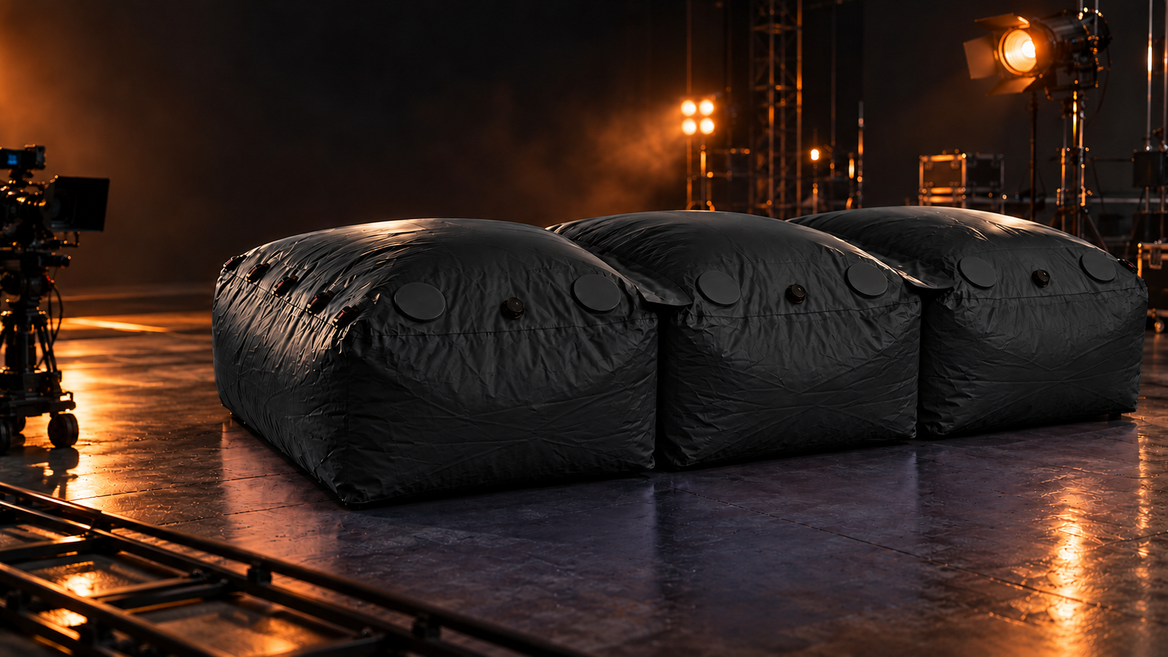 Three connected modular stunt bags in black on a film soundstage