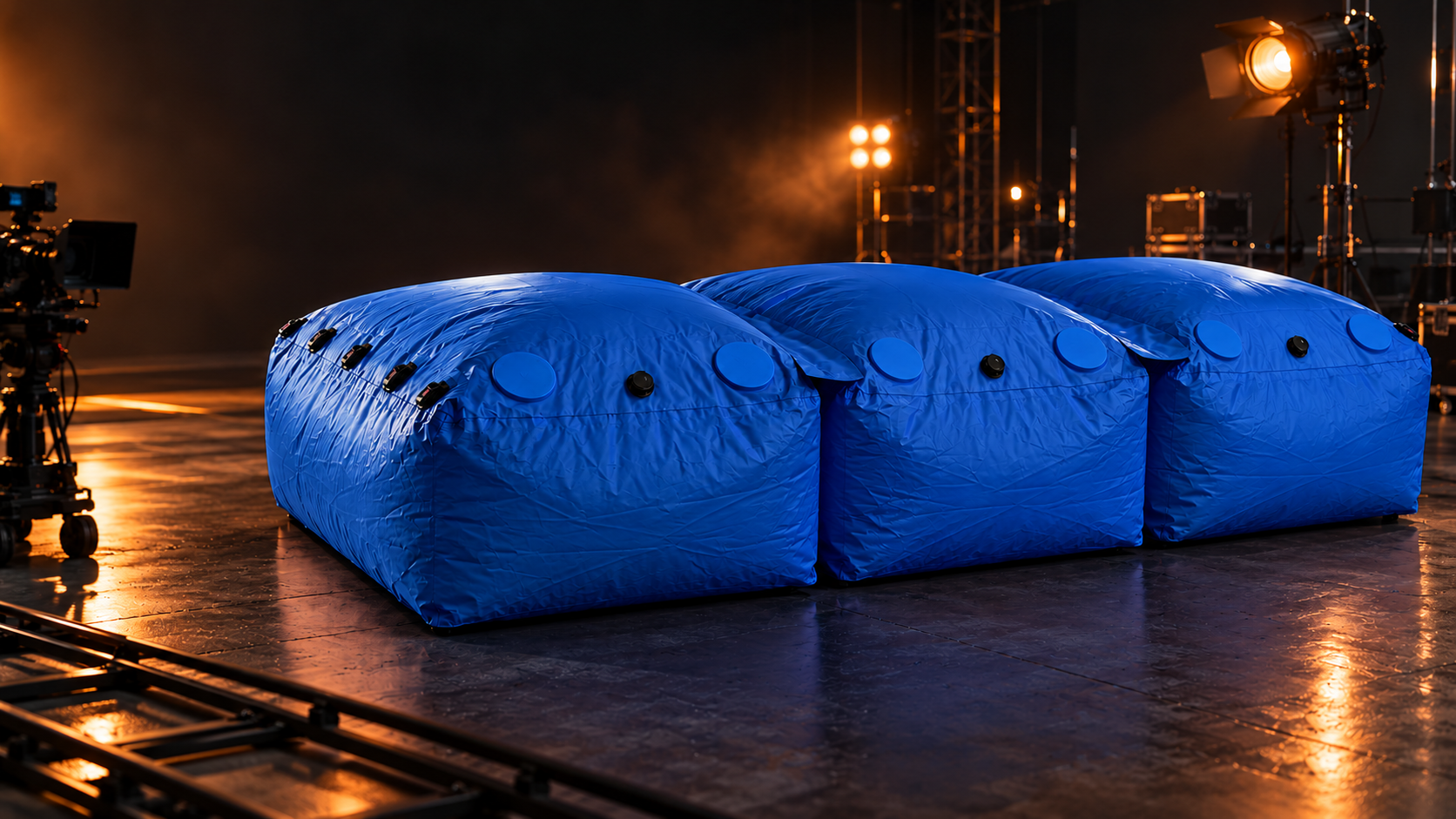 Three connected modular stunt bags in production blue on a film soundstage